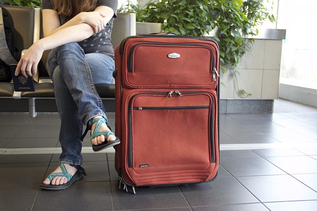 Person seated with suitcase next to them