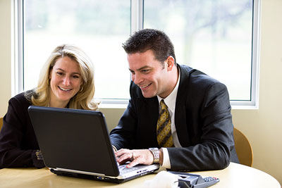 Two people talking around a laptop