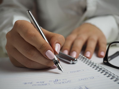 A person writing on a notepad
