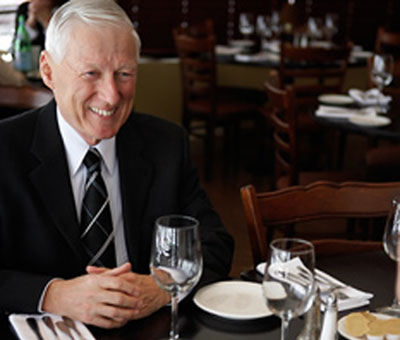 A man smiling at a dinner table business meeting