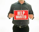 Top 4 Hiring Strategies for Start-Ups and SMBs with person holding a help-wanted sign
