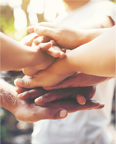 People supporting each other by placing their hands on top of one another